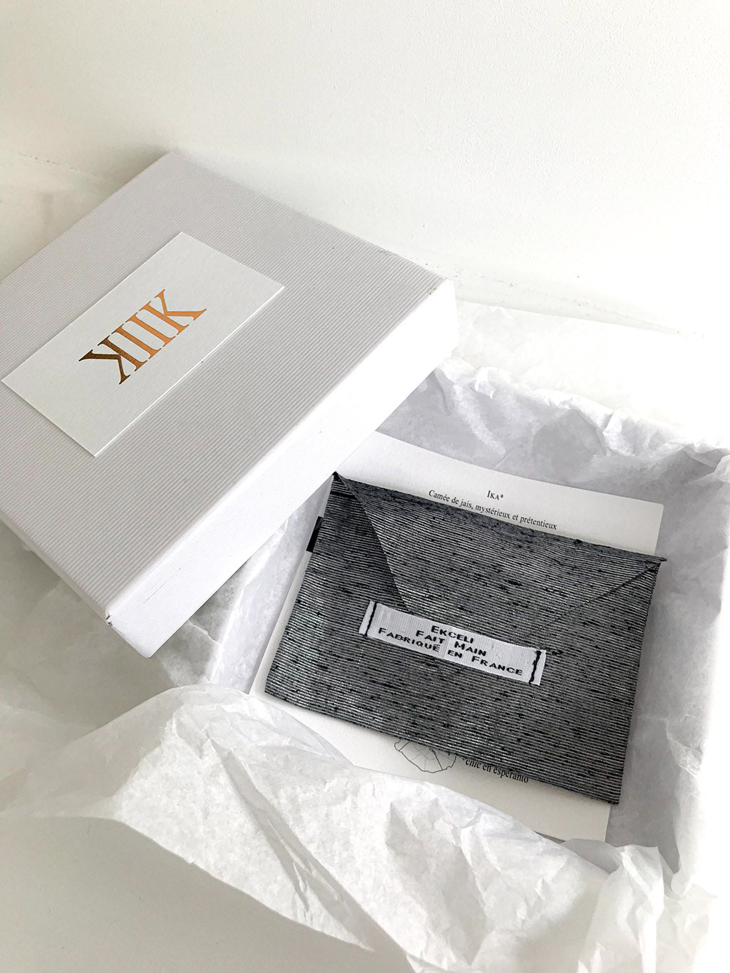 Visuel de la broche Paris Chic dans son coffret, avec sa pochette de rangement et son certificat d'authenticité.