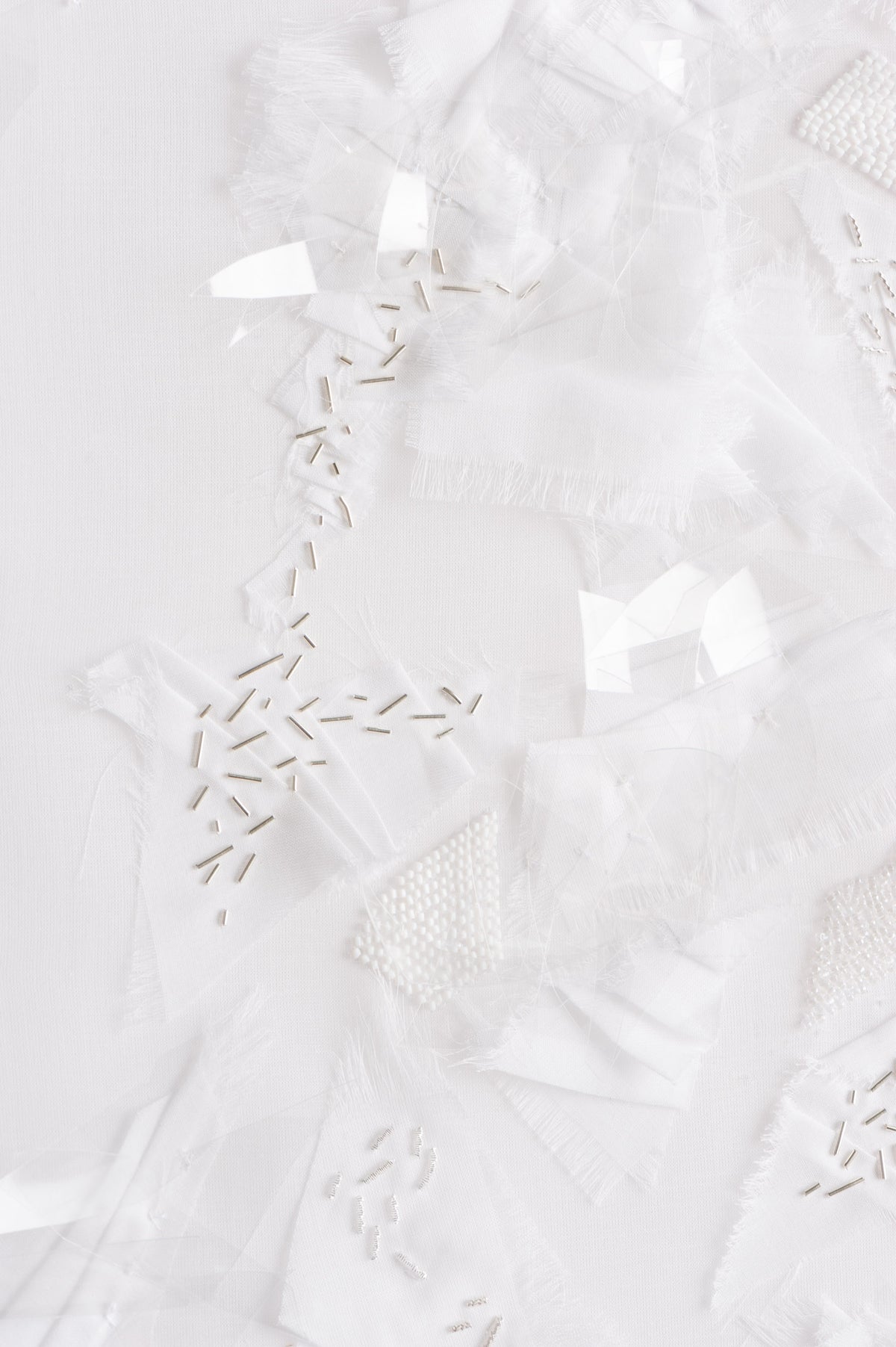 Zoom sur l'oeuvre Opalin. Toile blanche vêtue d'une multitude de fournitures de couleur blanches.