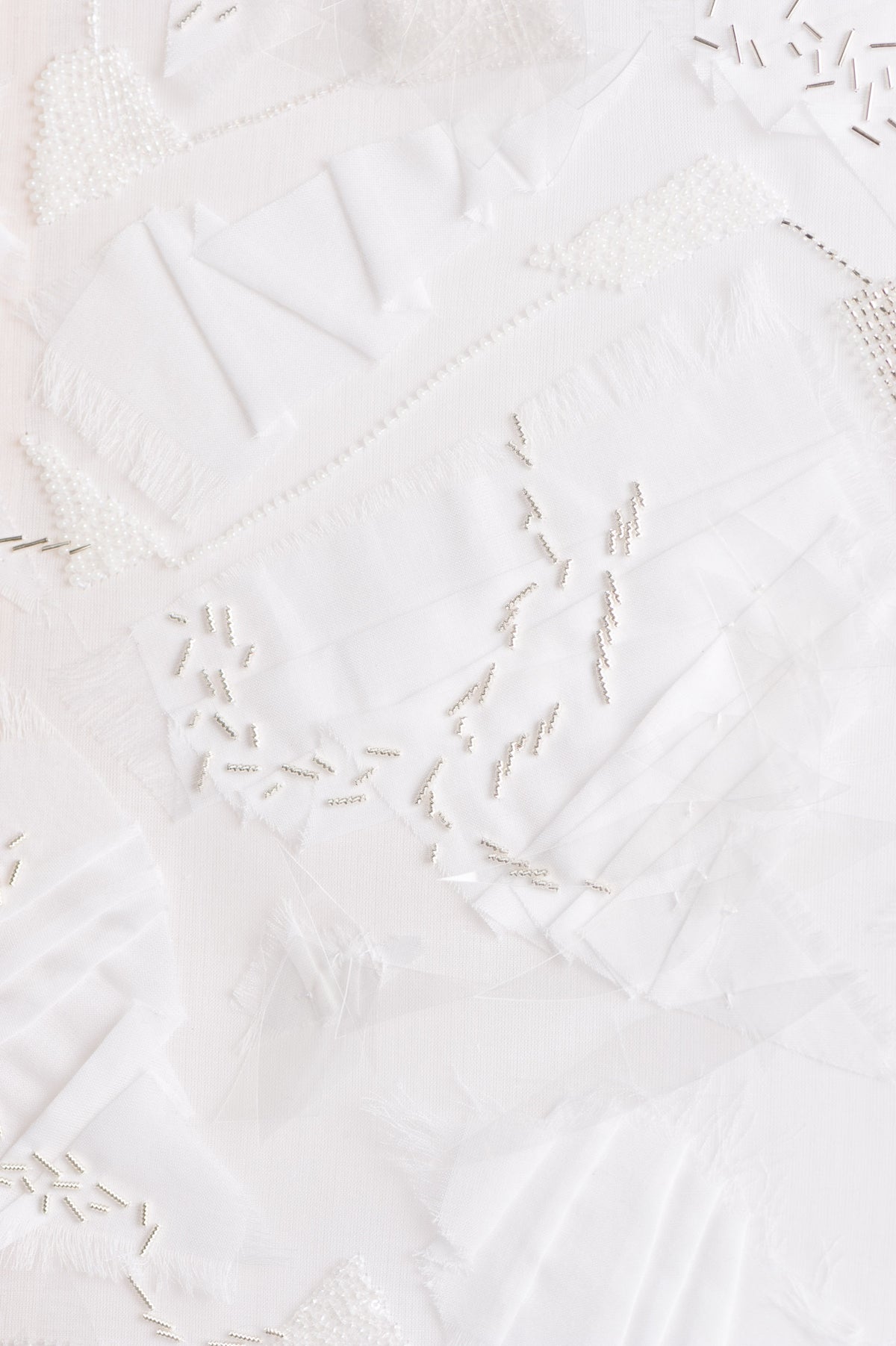 Zoom sur l'oeuvre Opalin. Toile blanche vêtue d'une multitude de fournitures de couleur blanches.